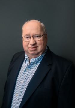 Man with glasses wearing suit.